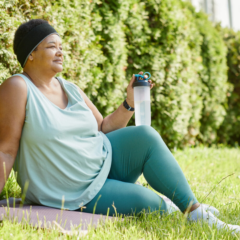 Lady resting on the grass after exercising outdoors working towards her Healthy Weight For Life