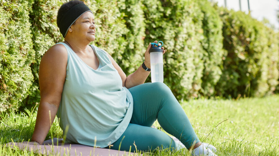 Lady resting on the grass after exercising outdoors working towards her Healthy Weight For Life