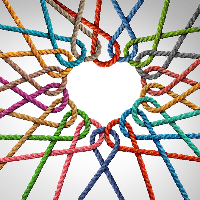 Unity and love partnership as ropes shaped as a heart in a group of diverse strings connected together shaped as a support symbol expressing the feeling of teamwork and togetherness.